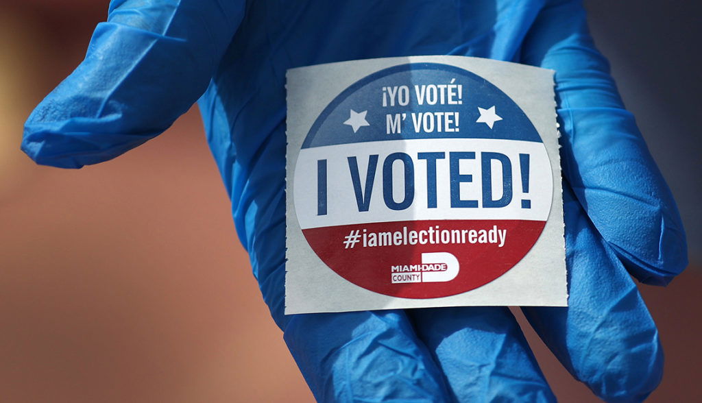 Florida Holds Presidential Primary Amid Coronavirus Pandemic MIAMI BEACH, FL - MARCH 17: A voter holds an, 'I Voted!', sticker after wearing a glove as she cast her ballot during the Florida presidential primary as the coronavirus pandemic continues on March 17, 2020 in Miami Beach, Florida. People are heading to the polls to vote for their Republican and Democratic choice in their parties’ respective primaries during the COVID-19 outbreak. (Photo by Joe Raedle/Getty Images)