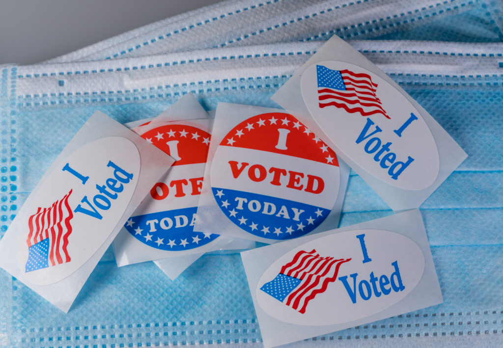 I Voted Today paper sticker on medical face mask to illustrate in person voting I Voted Today sticker on protective face mask for in person voting in the election in the USA during coronavirus pandemic
