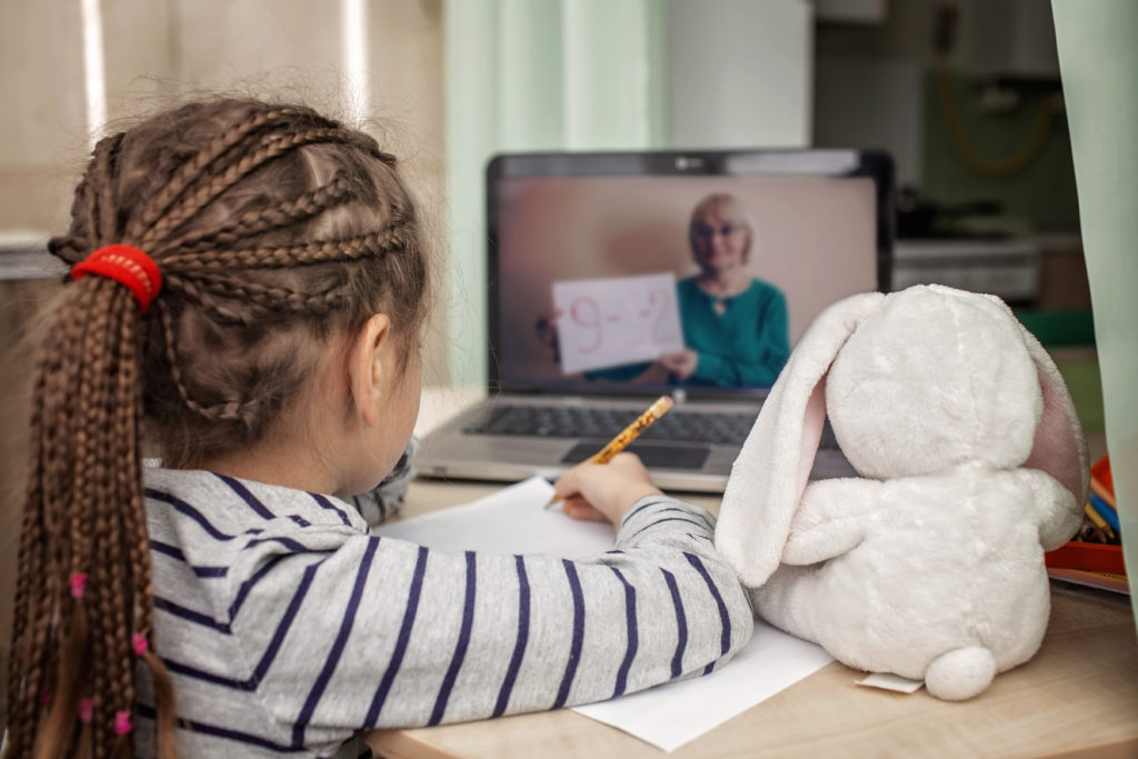 Pretty stylish schoolgirl studying math during her online lesson at home, self-isolation Pretty stylish schoolgirl studying math during her online lesson at home, social distance during quarantine, self-isolation, online education concept