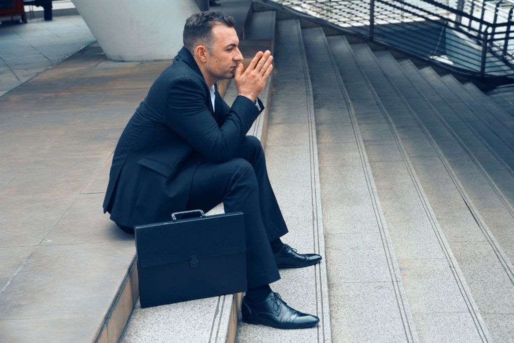 Businessman sit on the stairs and pray for apply job , layoff concept. Businessman sit on the stairs and pray for apply job , layoff concept.