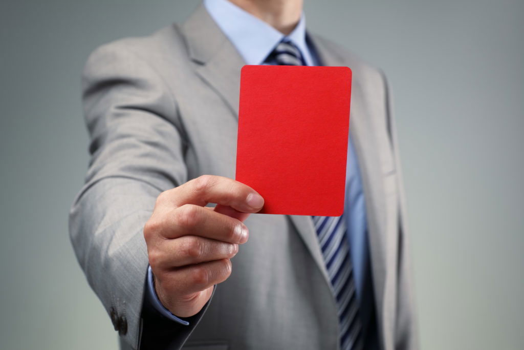 Businessman showing the red card Showing the red card concept for bad business practice, exclusion or criminal activity