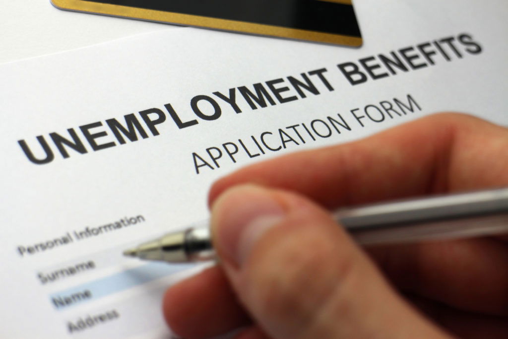 Someone 'signing on' Someone completing an unemployment benefits form.