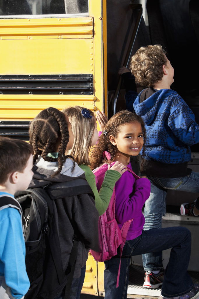 Children boarding school bus Multi-ethnic elementary students (ages 5 to 9) boarding school bus.