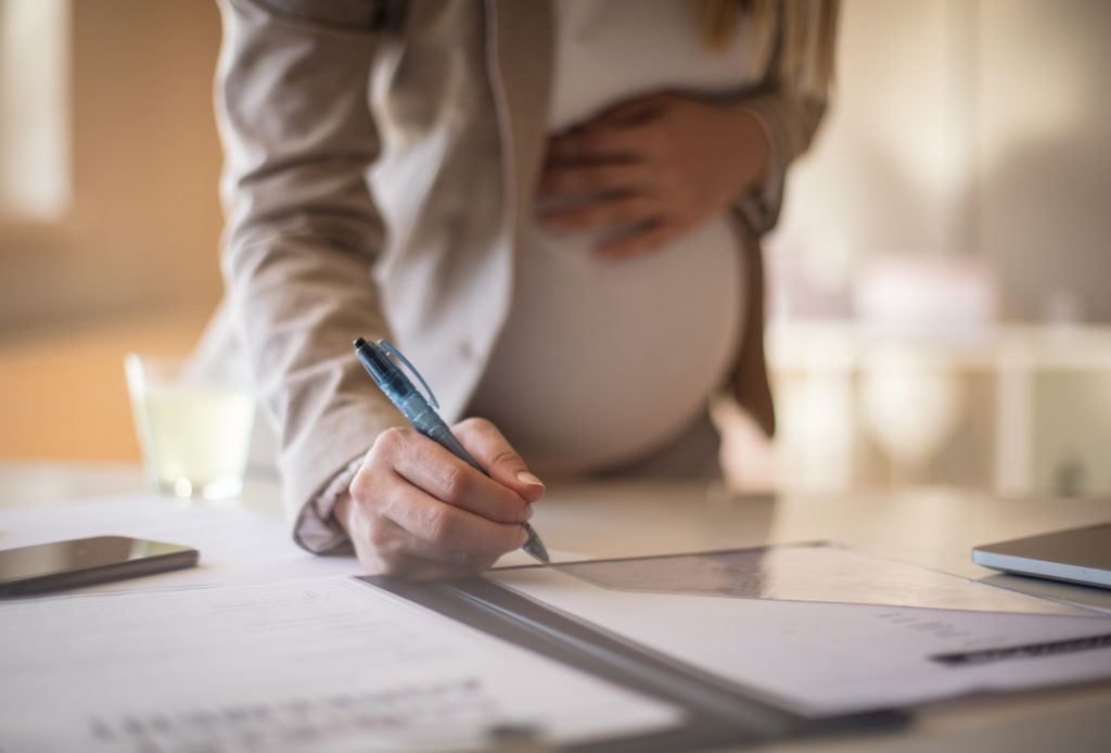 Complete all the jobs before the baby comes to the world. Pregnant business woman working. Close up.